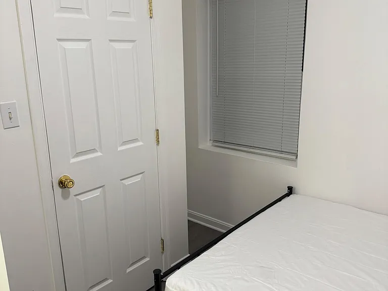 Private bedroom with a bed frame, easy-care flooring, and a window with blinds for light and privacy.