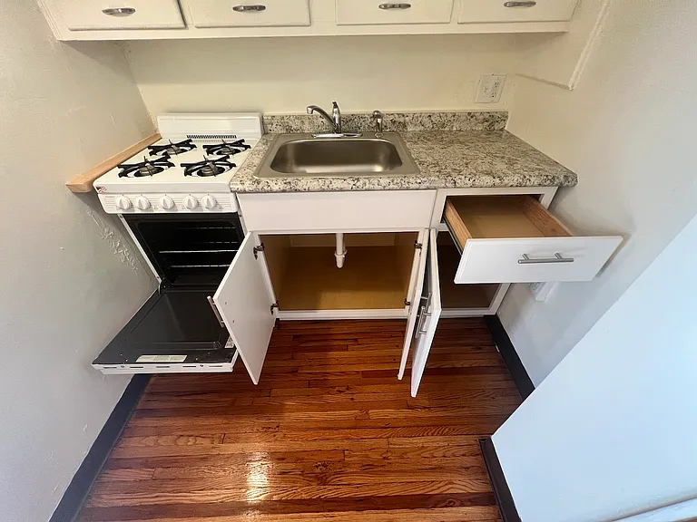 Cabinet space below kitchen sink.