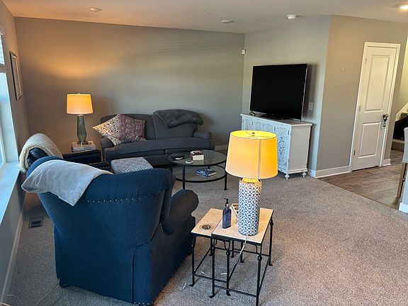 Living room right off the kitchen, with patio door leading out to deck