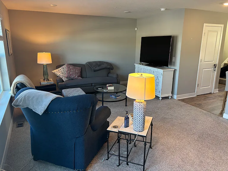Living room right off the kitchen, with patio door leading out to deck
