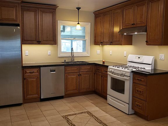Designer kitchen cabinetry, deep stainless steel dual sink, stainless steel dishwasher and refrigerator.