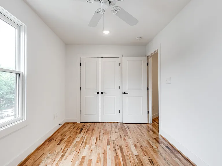 Second bedroom features hardwood floors, ceiling fan, sunny window, and double closet