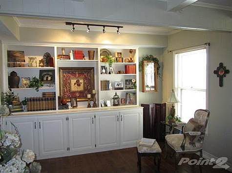 The Living Room features a large, built-in bookcase and display cabinet.