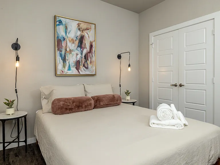 Stylish second bedroom featuring a queen bed and elegant Art Deco pendant lights on each side_designed for comfort with a touch of glamour. This bedroom is located upstairs.