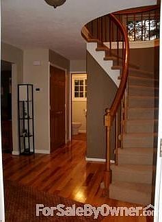 Foyer w/ Curved Staircase
						:
						1/2 bath visible at the end of the hallway.