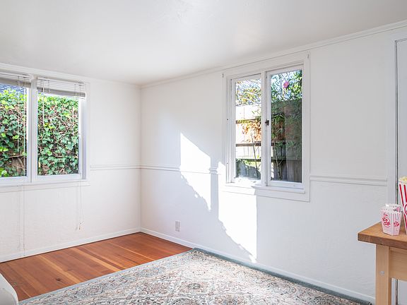 Bedroom with gorgeous natural light that looks into backyard with small space for sitting.