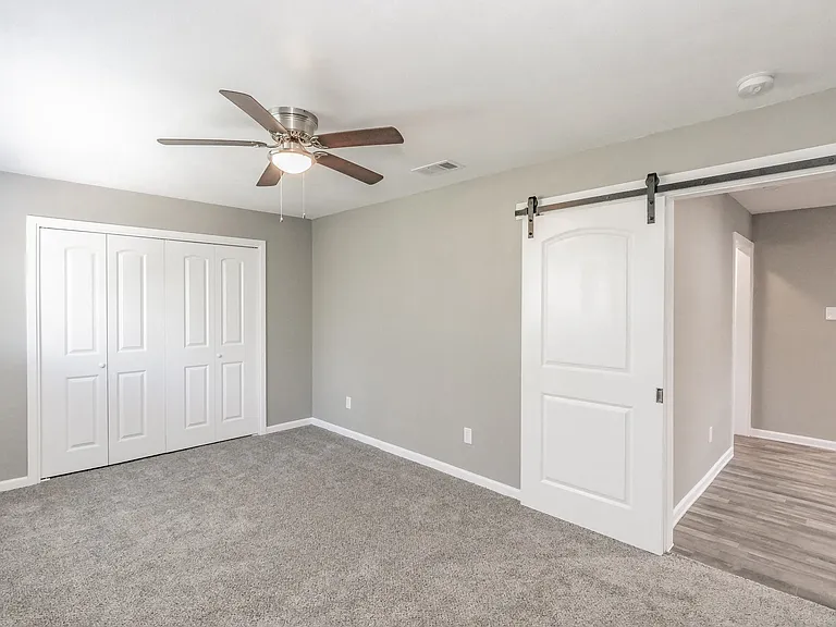 Bedrooms feature neutral finishes, ceiling fans, and ample natural light at Chapel Creek Apartments.