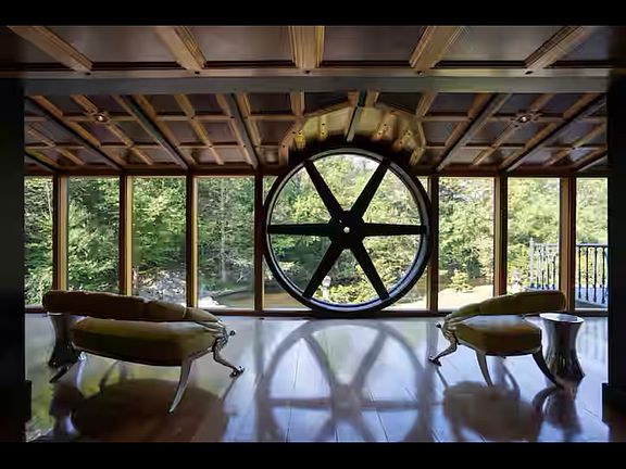 from front door opens up to back view of middle of open area room windows the length of the large main room.