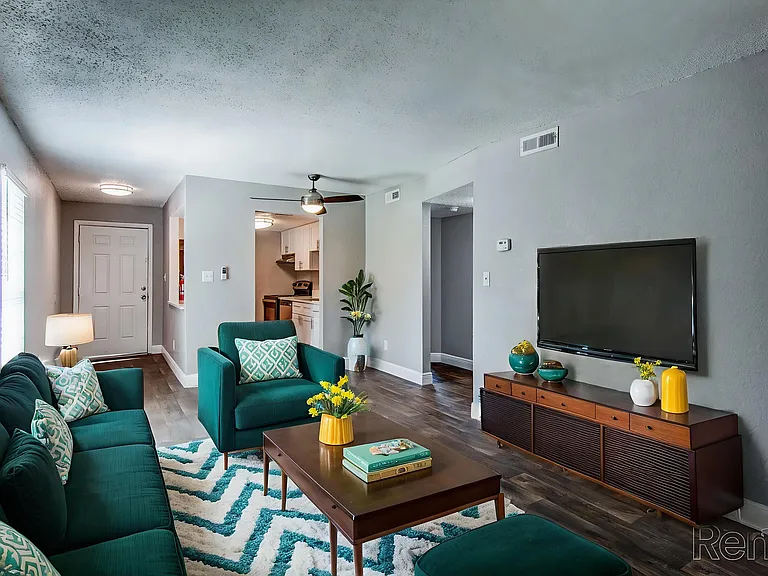 Inviting living room with elegant teal sofas, geometric-patterned rug, and modern decor, creating a cozy and stylish atmosphere. Inviting living room with elegant teal sofas, geometric-patterned rug, and modern decor, creating a cozy and stylish atmospher
