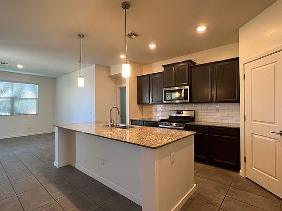Large kitchen island with granite counters and plenty of room for barstools