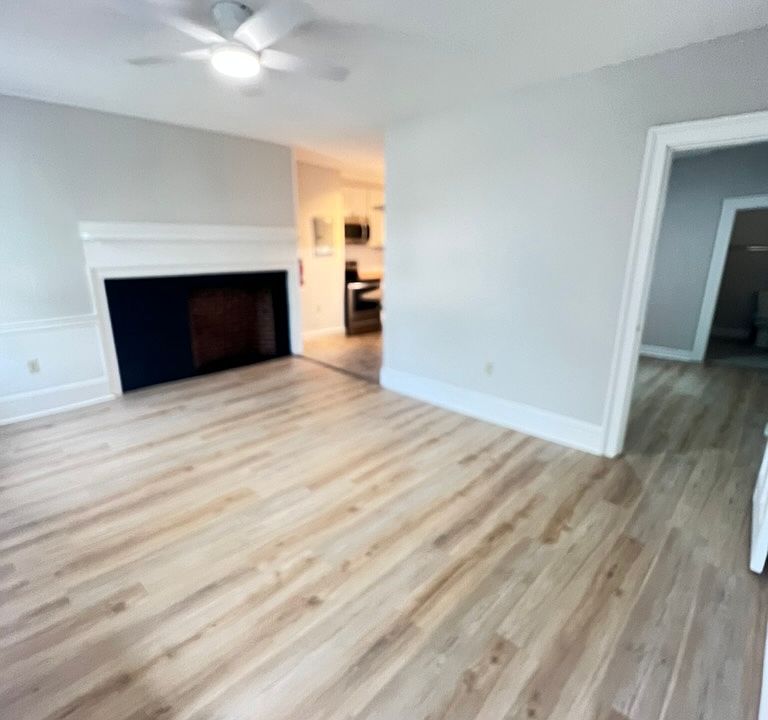 View from entrance, new LVP flooring, ceiling fan and a large fireplace