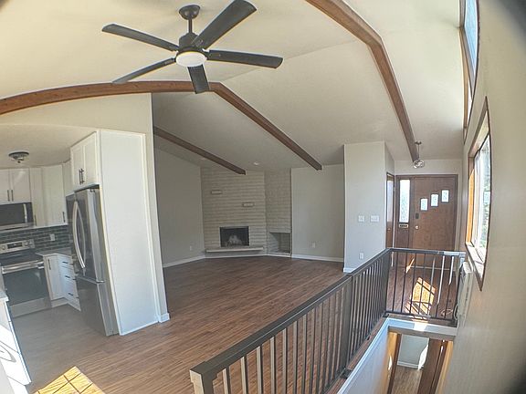 11 foot vaulted ceiling, bright living room (16 x 22 feet) with cozy wood burning fireplace