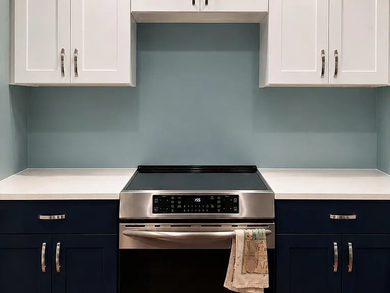 Kitchen cooking zone with stainless range, ample shaker cabinets, and wide counters for meal prep and storage.