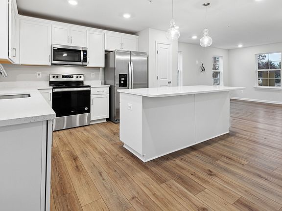 White Cabinets, Quartz Counters, and Stainless Steel Appliances in the Whitehall at Village of Colle