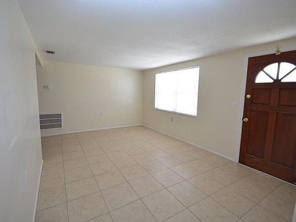 ENTRYWAY LEADS INTO LIVING ROOM WITH TILE FLOORING
