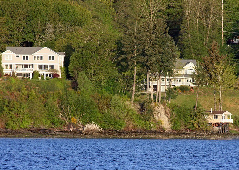 View of the rear of the home (on left) as seen from the vicinity of the Poulsbo Yacht Club. The Master suite occupies to upper right portion of the home. The neighbor to the North sits well behind this home and is on a parcel of substantial acreage.