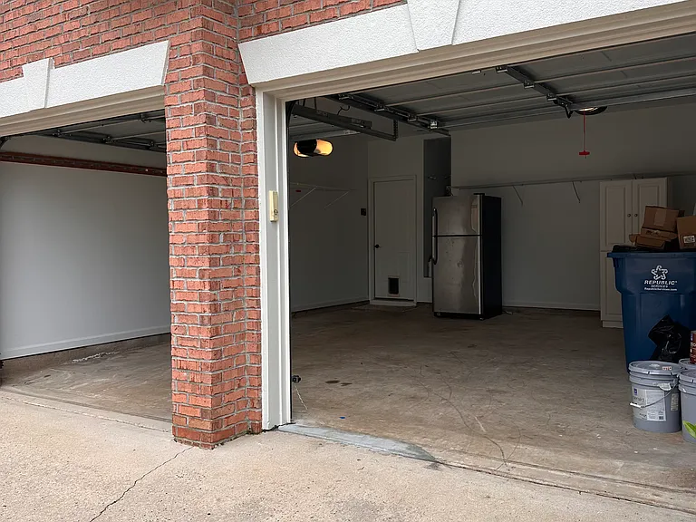 2 Car Garage, completely repainted in January 2026. Includes Extra Refrigerator, Shelving and Storage Cabinets for your use!