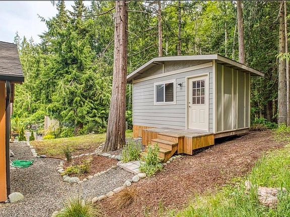 Detached studio and forested rear of the property.