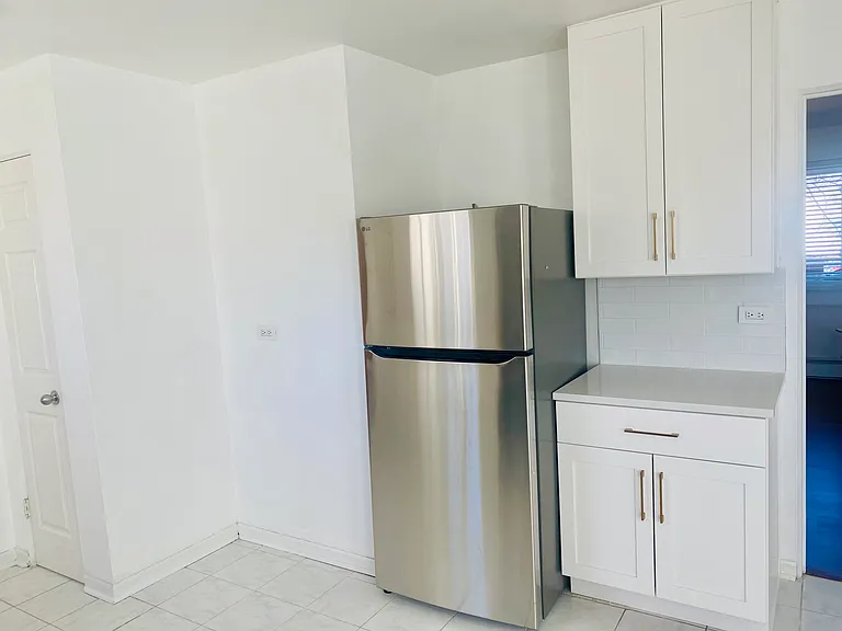 Pantry on left, new quartz countertops throughout kitchen and undercabinet lighting.