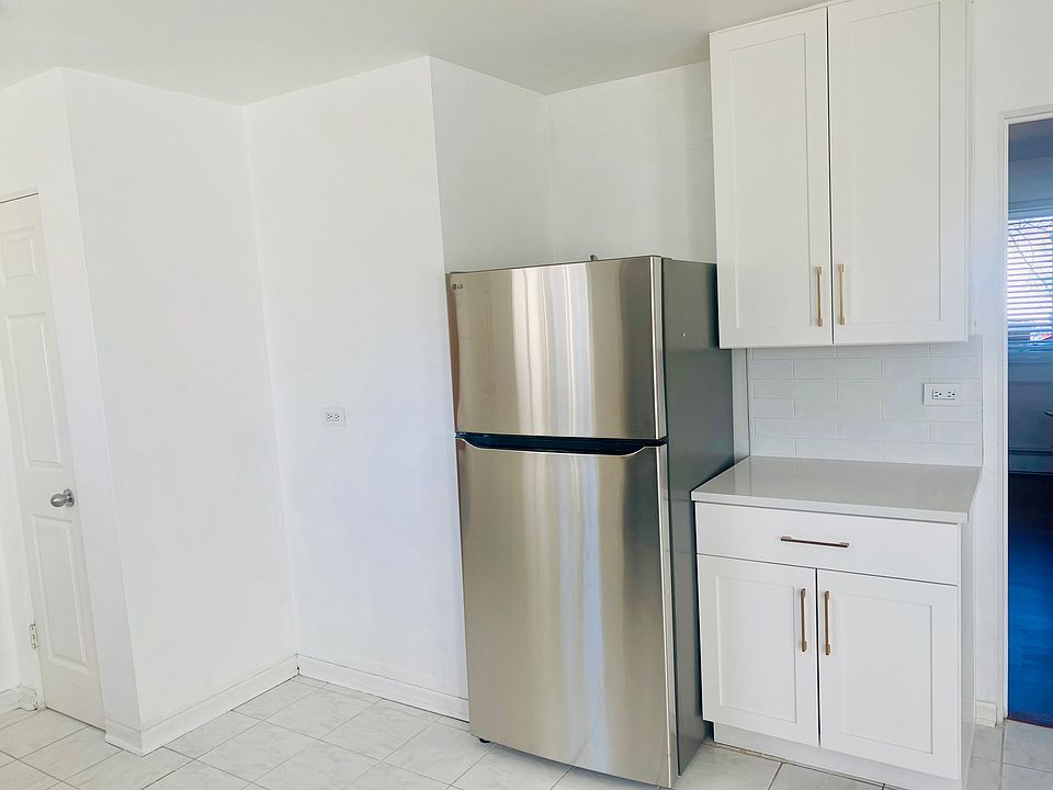 Pantry on left, new quartz countertops throughout kitchen and undercabinet lighting.