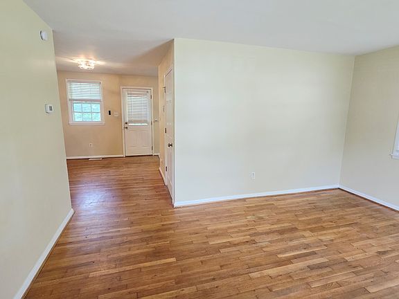Living Room/Entry with natural hardwood floors and new modern fan/light for dining area.