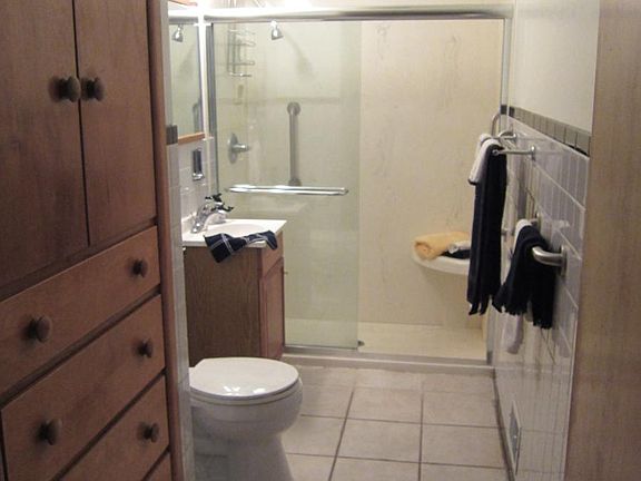 Tiled bathroom with beautiful built-in wooden storage