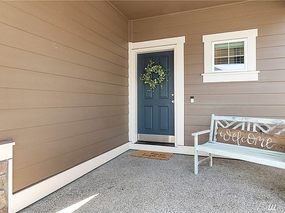 Spacious covered porch with plenty of room for outside seating is welcoming.