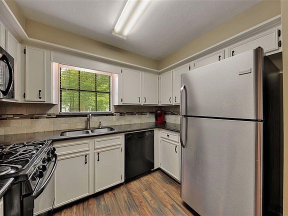 Kitchen has been upgraded to granite counters, wood look tiled flooring and has a gas range and beautiful view to enjoy while doing the dishes !