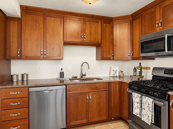 Cherry cabinetry with granite counters and stainless steel appliances