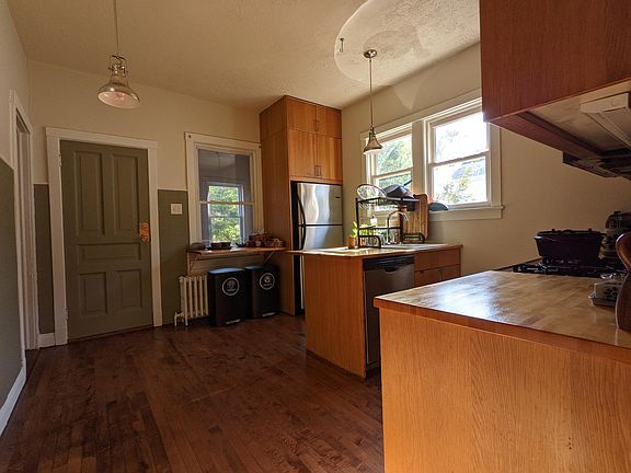 Kitchen; the bathroom and second bedroom branch to the left. The door ahead leads to an enclosed staircase with a private bonus room.