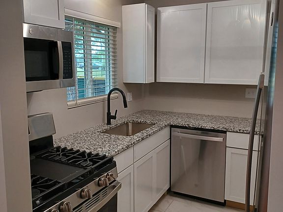 Completely new Kitchen - stainless steel appliances, new cabinets, stone countertops, contemporary lights, new tile