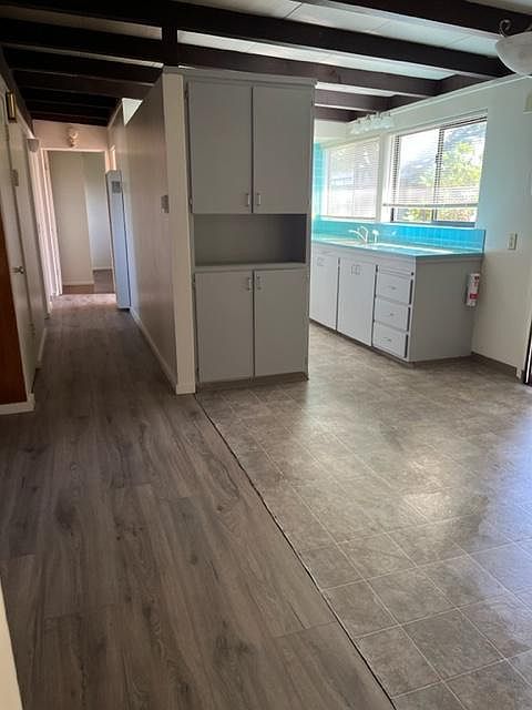 Kitchen/dining room area. Cabinets freshly painted. Bedrooms and bathroom down the hall.