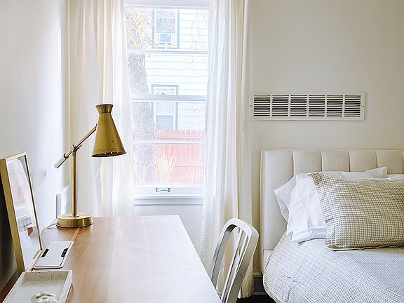 Bedroom with large desk, queen bed, and walk in closet