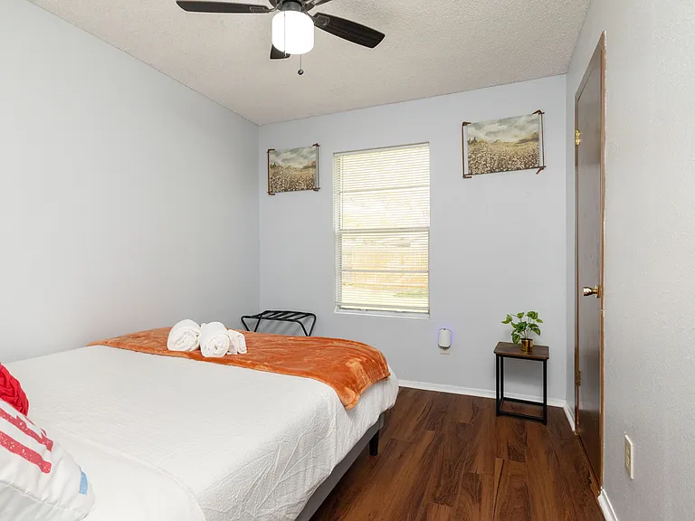 This charming bedroom is equipped with a queen bed, a ceiling fan, and a window for plenty of natural light.