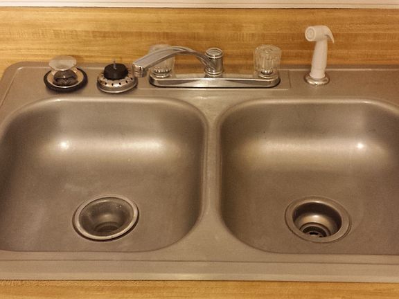 like new stainless steel dual compartment sink.like new fauc
