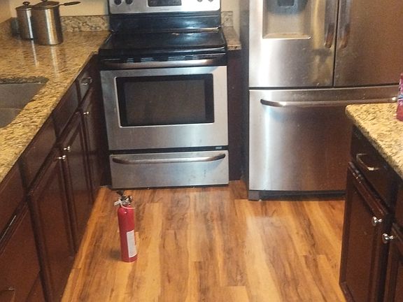 stove in kitchen with over head microwaved