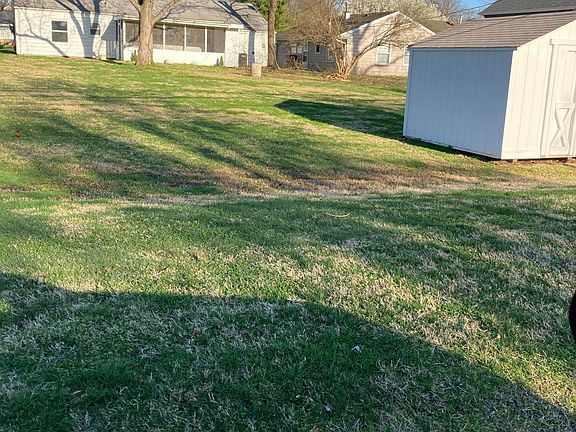Backyard view with screened porch showing.