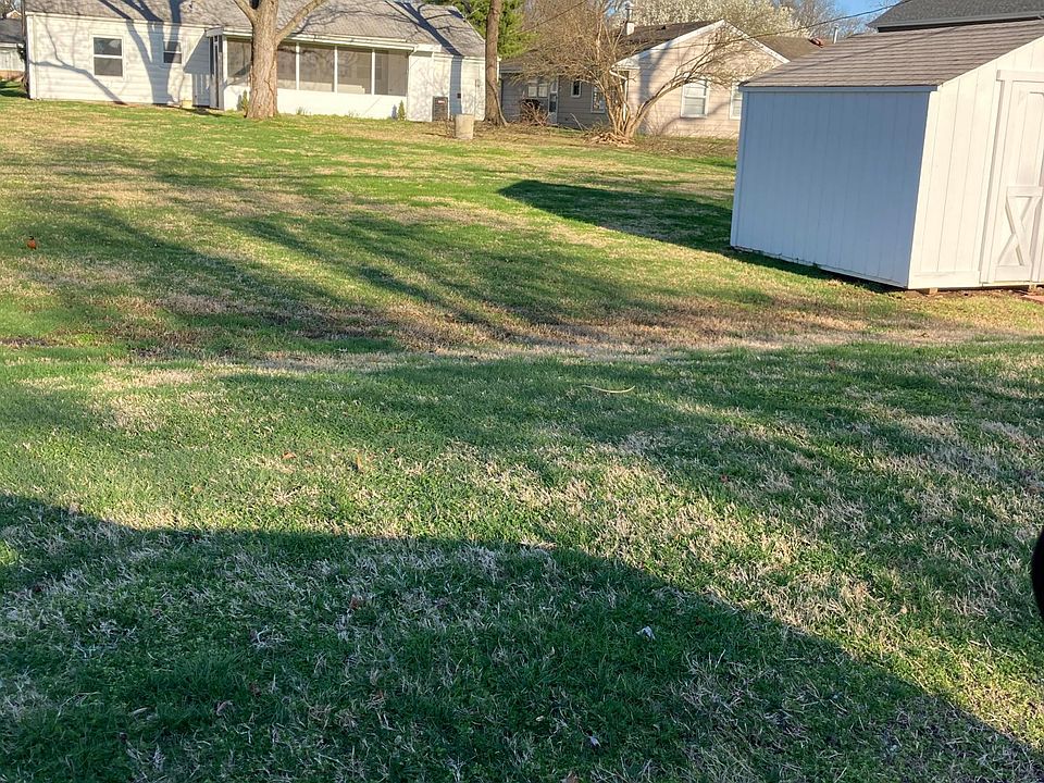 Backyard view with screened porch showing.