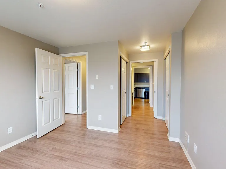 Spacious apartment bedroom with wood-style flooring.