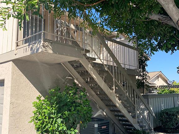 Front view of condo with hibiscus tree under stairway