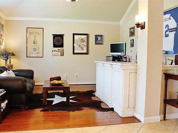 This formal living area features beautiful wood floors and crown molding and is being used as a bar/sitting area (bar does not stay) but could also make a great study or gameroom.