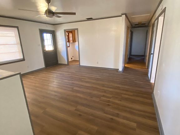 same view just standing beside island looking down hallway to bedrooms