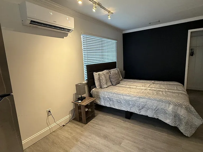Modern bedroom with A/C, window with stylish blinds, and great natural light.