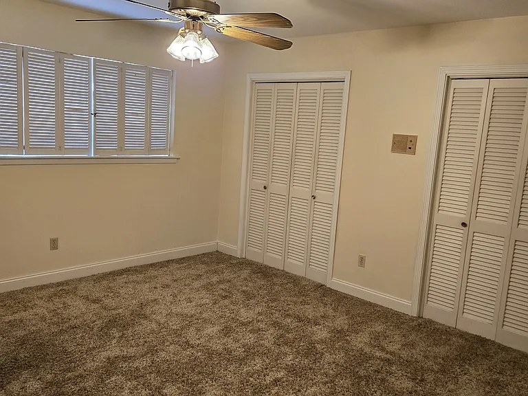 Third bedroom on second floor with ceiling fan and double door closets.