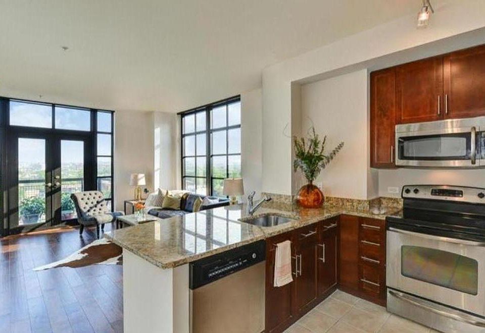 Kitchen and Family Room with balcony. Unobstructed city views. Can see sunrise to the east (right window).