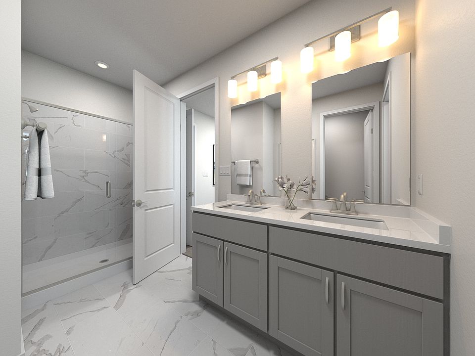 The primary bathroom offers dual vanity sinks and a walk-in shower.