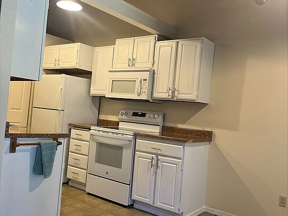 Cathedral ceiling in the white clean kitchen and dining area too