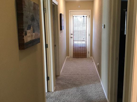 Hallway to bedrooms and backdoor to patio