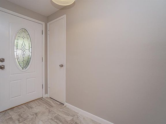 Entry hall: beautiful leaded front door, coat closet, and ceramic tile Soft gray color scheme throughout the home.