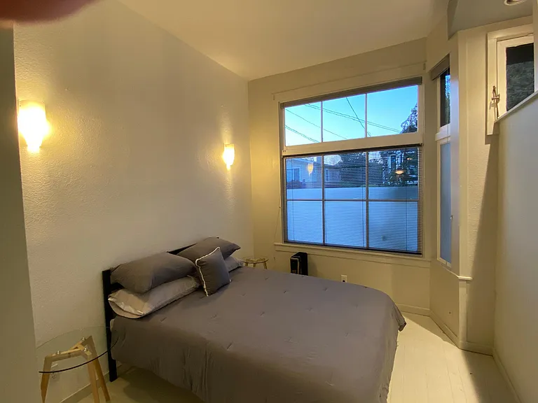 King-Size Bed with memry foam topper. Black-out window coverings on upper and lower windows in this space (some light will come over wall from living area)